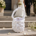 White BRIDAL CROCHET BAG With 'UNA' branding on steps with a blurred wedding couple in the background.