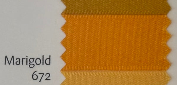 Close-up of marigold fabric swatch with color code 672 on a light gray background